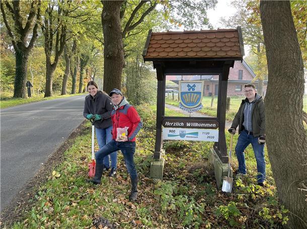 Drei Männer an einer Straße mit einem Schild