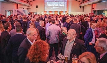 Viele Menschen in einem Saal. 
