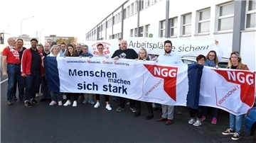Menschen mit einem Plakat bei einer Demonstration.