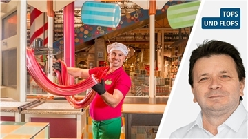 Ein Mann in der Bonbonherstellung und ein anderer Mann in einem weißen Hemd. 