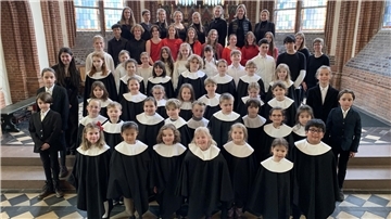Kinder und Jugendliche haben sich in einer Kirche aufgestellt.