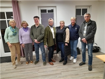 Eine Gruppe Frauen und Männer blickt in die Kamera.