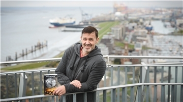 Ein Schriftsteller hält sein neues Buch in den Händen. 