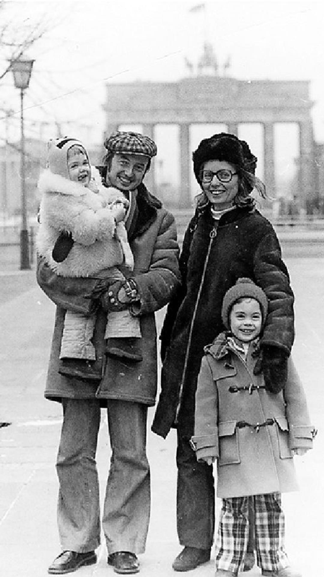 Eine Familie steht in den 70er Jahren vor dem Brandenburger Tor in Ost-Berlin auf der Straße "Unter den Linden". 