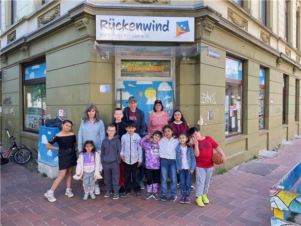Kinder und Erwachsene stehen vor der Eingangstür des Projektes Rückenwind.