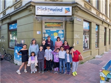Kinder und Erwachsene stehen vor der Eingangstür des Projektes Rückenwind.