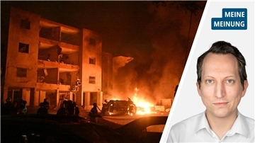 Zwei Drittel des Bildes zeigen ein Gebäudeteil in Flammen. Daneben ein Autowrack. Es ist Nacht. Tel Aviv in Israel wurde von iranischen Raketen getroffen.  