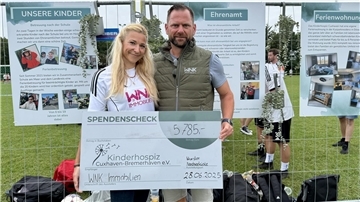 Ein Mann und eine Frau mit einem Riesenscheck