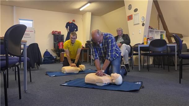 Bei einem Erste-Hilfe-Kursus üben zwei Teilnehmer die Herzdruckmassage an Puppen.