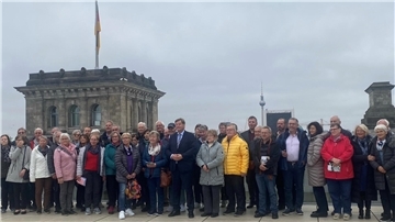 Große Besuchergruppe aus der Wesermarsch steht auf dem Dach des Reichtagsgebäudes in Berlin.