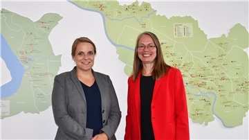 Bildungssenatorin Sascha Aulepp (SPD, rechts) begrüßt die neue Direktorin des Bremer Instituts für Qualitätsentwicklung (IQHB), Dr. Susanne Kollmann.