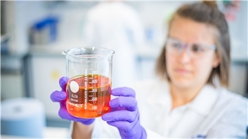 Biologielaborantin Carina Bösch zeigt die fertige Multivitaminlösung zur Tiernahrungsergänzung.