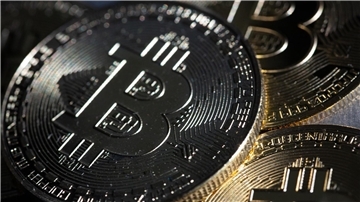 Bitcoin-Münzen liegen auf einem Tisch.