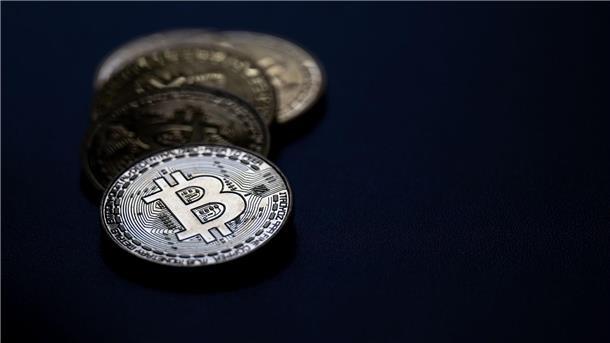 Preis für Bitcoin fällt nach Rekordhoch deutlich Bitcoin-Münzen liegen auf einem Tisch.