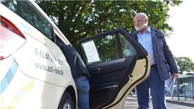 Dieter Schmidt, Inhaber der Rotenburger Firma Julia Reisen, hält einem Fahrgast die Tür auf.