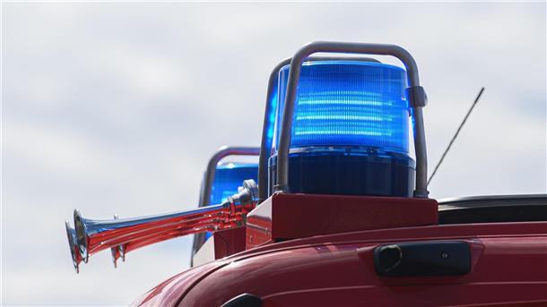 Blaulichter leuchten auf dem Dach eines Einsatzfahrzeugs der Feuerwehr.