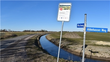 Blick auf den Wischweg bei Stollhamm. Hier ist der Graben bereits verlegt und ein Seiten-Schotterstreifen an die alte Fahrbahn angebaut worden.