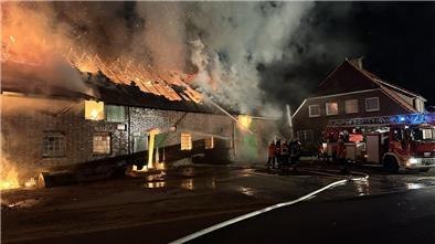 Blick auf die Scheune mit dem Wohnhaus im Hintergrund. Gerade wird die Drehleiter in Stellung gebracht.