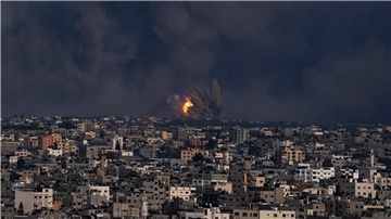 Blick über Gaza-Stadt. Feuer und  Rauch steigen nach einem israelischen Luftangriff auf.