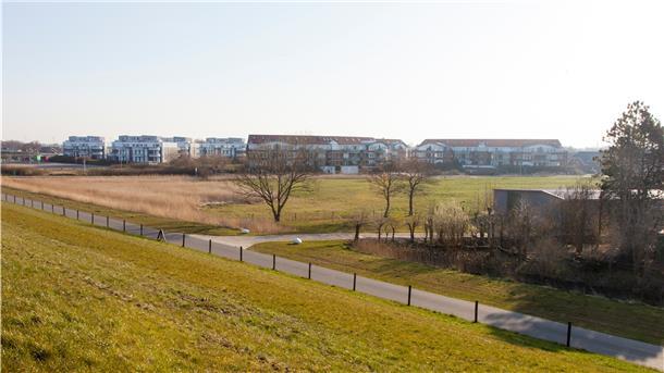 Blick vom Seedeich in Dorum-Neufeld: Auf der grünen Wiese zwischen den Siedlungsteilen im Vordergrund (rechts) und den Appartmenthäusern (links) soll das neue Hotel entstehen.