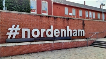 Die Flutmauer vorm Nordenhamer Bahnhof mit dem Schriftzug "#nordenham“.