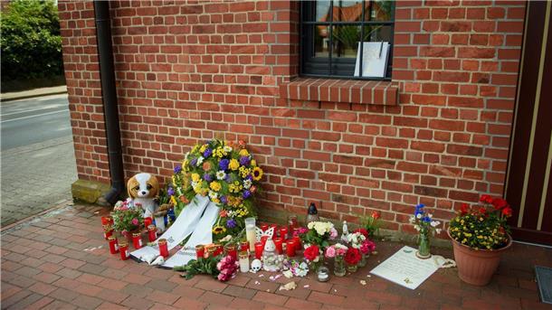 „Sind damit nicht allein“: Gottesdienst nach Radlader-Unfall Blumen, Stofftiere und Kerzen liegen vor dem Haus der Gemeindeverwaltung Toppenstedt.