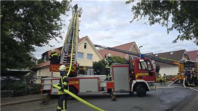 Mit zwei Drehleitern löschen Feuerwehrleute einen Dachstuhlbrand