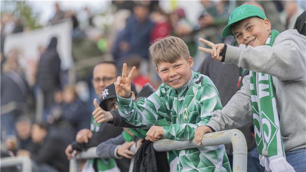 Zuschauer bei einem Fußballspiel auf der Tribüne. Es sind Fans von Werder Bremen.