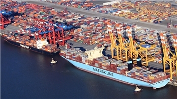 Luftaufnahme eines Containerterminals mit zwei großen Containerschiffen der Reedereien Hapag-Lloyd und Maersk, die an der Kaje liegen