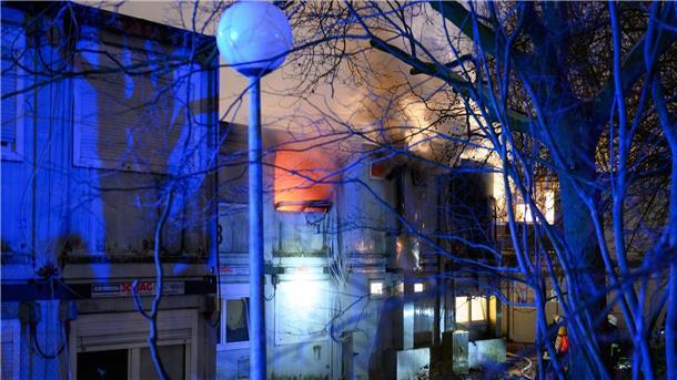 Brennende Container-Einheiten einer Flüchtlingsunterkunft in Hamburg-Winterhude - bei dem Feuer kam ein Mensch ums Leben.