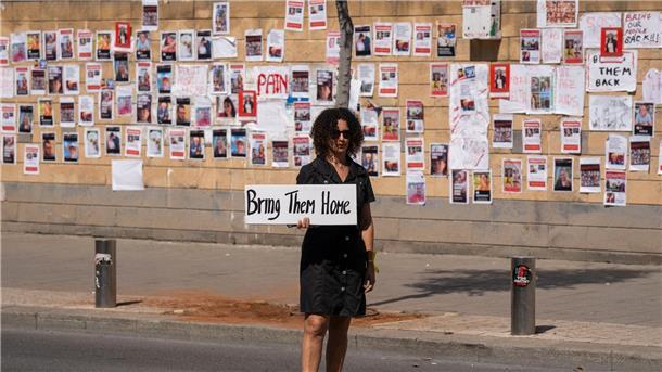 WHO rechnet Freitag mit Grenzöffnung in Rafah    „Bringt sie nacht Hause“ steht auf dem Schild dieser Frau, die in Tel Aviv vor einer Wand mit den Fotos von Israelis steht, die von der Hamas im Gazastreifen gefangen gehalten werden.