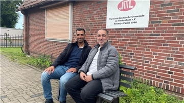 Zwei Männer sitzen auf einer Bank.