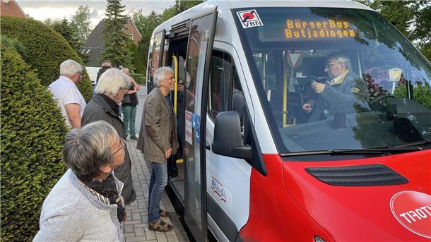 Einige Leute schauen sich einen Bürgerbus an.