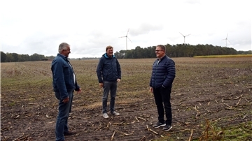 Bürgermeister Gerd Kaiser, Flächeneigentümer Jan-Christoph Wilkens und Carsten Lange von der EEG GmbH Sottrum stehen auf einem Feld.