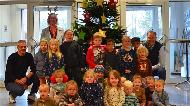 Bürgermeister Guido Dieckmann (hinten rechts) mit der Ersten Gemeinderätin Claudia Lühmann (hinten links stehend), dem Projektverantwortlichen Kai Wilkens (hinten links) und den Kita-Kindern vor dem geschmückten Wunschbaum im Beverstedter Rathaus.