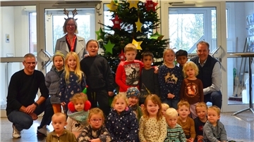 Bürgermeister Guido Dieckmann (hinten rechts) mit der Ersten Gemeinderätin Claudia Lühmann (hinten links stehend), dem Projektverantwortlichen Kai Wilkens (hinten links) und den Kita-Kindern vor dem geschmückten Wunschbaum im Beverstedter Rathaus.