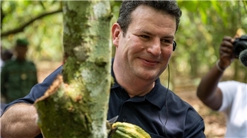 Bundesarbeitsminister Hubertus Heil erntet auf einer Kakaoplantage in Agboville an der Elfenbeinküste eine reife Kakao-Schote.