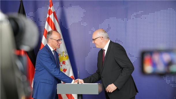 Bundeskanzler Friedrich Merz und der Bremer Landeschef Andreas Bovenschulte geben sich in Bremerhaven die Hand.