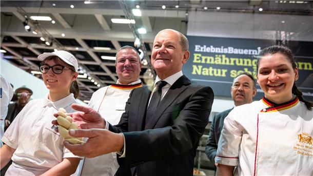 Teigzopf und Dialog: Der Kanzler auf der Grünen Woche Bundeskanzler Olaf Scholz mit Hefezopf beim Besuch der Schaubäckerei auf der Grünen Woche.