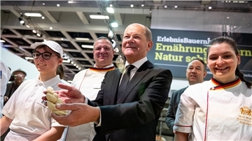 Bundeskanzler Olaf Scholz mit Hefezopf beim Besuch der Schaubäckerei auf der Grünen Woche.