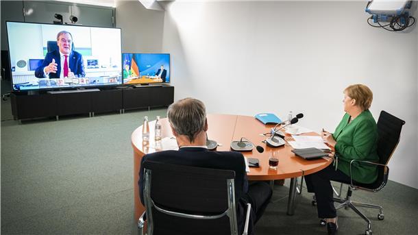 Bundeskanzlerin Angela Merkel (r) und Markus Söder, Ministerpräsident von Bayern und Vorsitzender der Ministerpräsidentenkonferenz, sprechen während einer Videokonferenz mit den Ministerpräsidenten der Länder über Schutzmaßnahmen der Bevölkerung während der Coronavirus-Pandemie. Auf dem linken Bildschirm ist Armin Laschet, Ministerpräsident von Nordrhein-Westfalen, zu sehen.