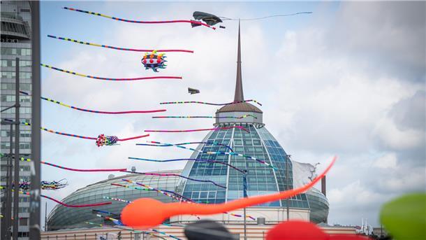 Bunte Drachen sind am Himmel über der Kuppel des Outlet-Centers Bremerhaven zu sehen.