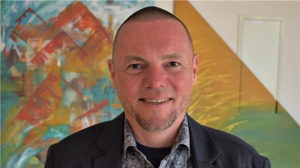 Ein Mann vor einer bunten Wand. Butjadingens Kämmerer Jens Kühne hat überraschend gekündigt.