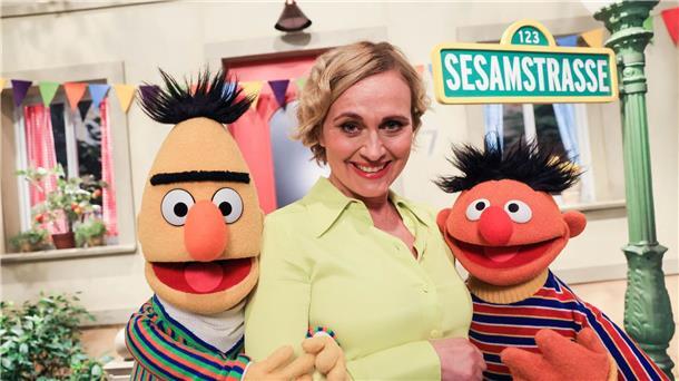 Caren Miosga, Moderatorin der ARD-“Tagesthemen“, und die Figuren Ernie (r) und Bert bei Dreharbeiten am Studio-Set der „Sesamstraße“.