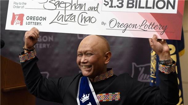Krebskranker US-Lottospieler knackt Milliarden-Jackpot Cheng Saephan hält einen Riesencheck in Höhe von 1,3 Milliarden Dollar in die Höhe.