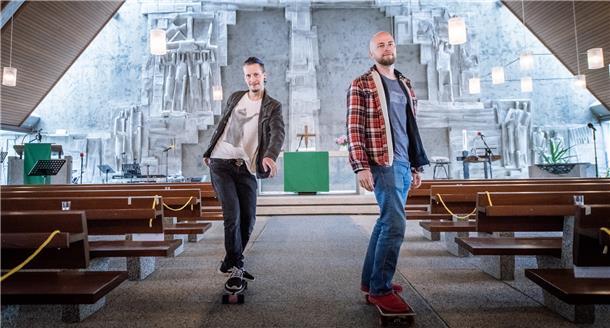 Chris Schlicht (rechts) und Max Bode posieren auf ihren Skateboards in der Kirche.