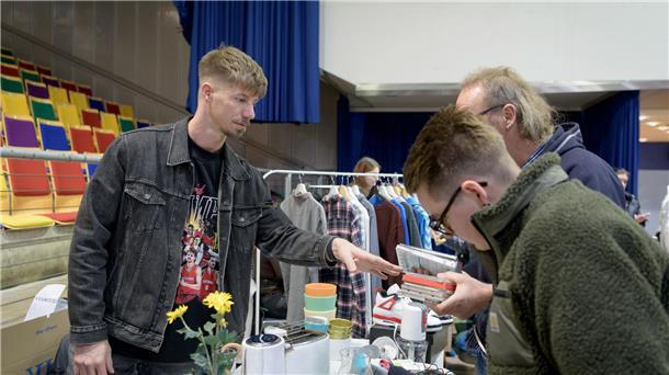 Flohmarkt in der Bremerhavener Stadthalle: Das ist ein bisschen wie Jagen Mann erklärt zwei anderen Männern etwas