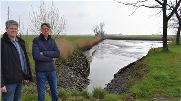 Christoph Ley (links) und Klaus Mahnken von der Wassersportgemeinschaft Absersiel stehen am dortigen Spülteich, der dringend von großen Schlickmengen befreit werden muss.
