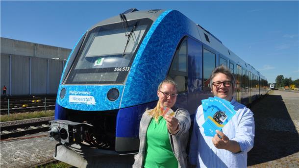 Christoph Nagel und Lena Kaplan von der Unternehmenskommunikation der EVB weisen auf die historischen Fahrkarten hin, die für Sonderfahrten zum Bahnhofsfest erhältlich sind. 
