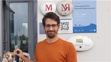 Junger Mann steht vor einer Hauswand. Es ist der Umweltanalytiker Christopher Dibke. 